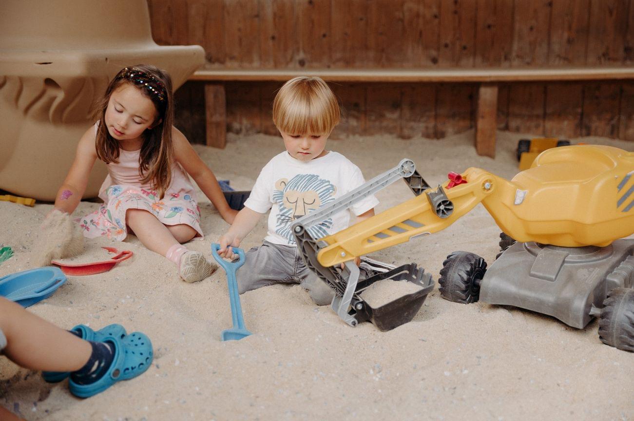 Children play in the huge covered sandpit with toys